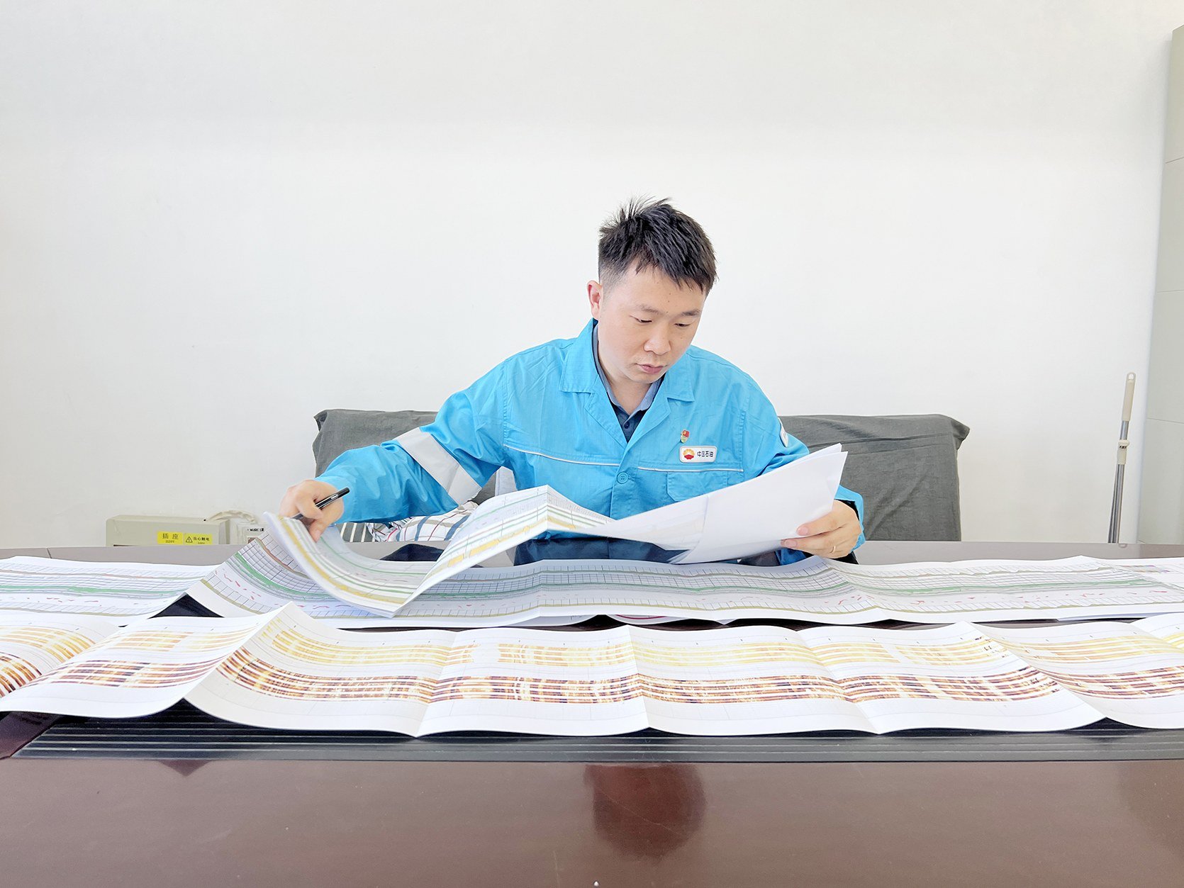 周炬锋(中)带领团队同事开展研究讨论。
周炬锋严格审核每一份资料图件。本版图片由中油测井新疆分公司提供